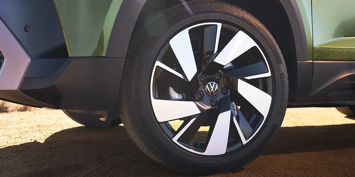 Close-up of Volkswagen Taos alloy wheel and fender design, highlighting its bold black-and-silver wheel finish and modern craftsmanship.