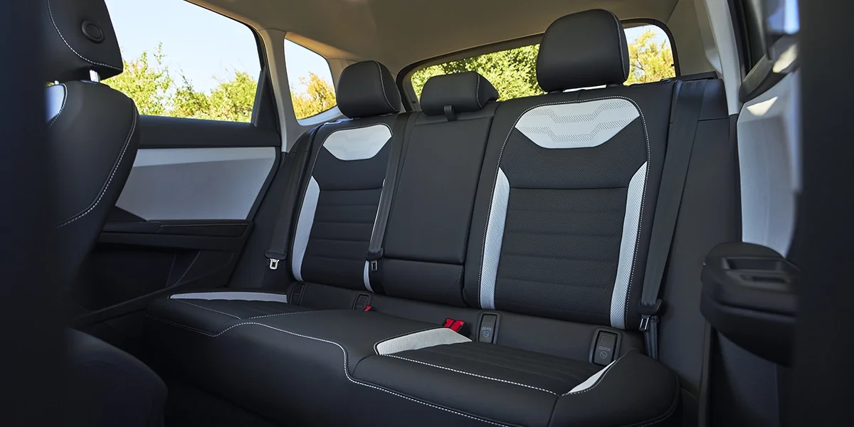 Rear seating of Volkswagen Taos featuring premium black and gray upholstery with contrast stitching for a modern, comfortable cabin.