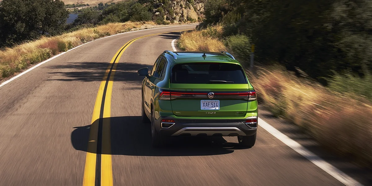 Volkswagen Taos SUV cruising on an open scenic highway, capturing its aerodynamic design and sporty driving dynamics.
